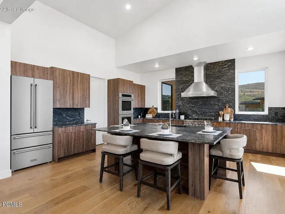 Gourmet kitchen with walnut cabinetry, stone island, and mountain views